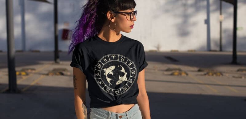 A model wearing a black t-shirt with a drawing of astrological symbols.
