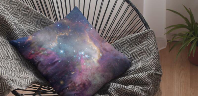 A decorative pillow with a galaxy print.
