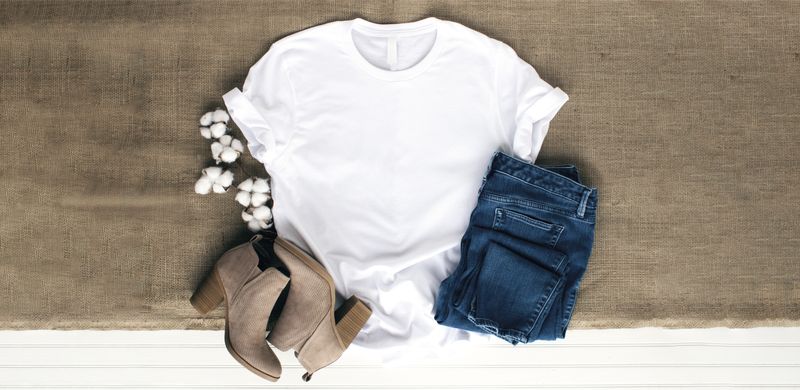 A bird's eye view of a white t-shirt, brown boots, and blue jeans.