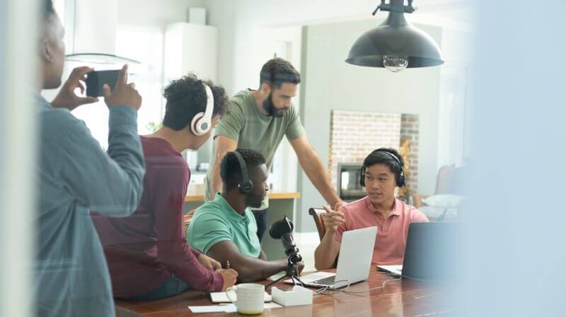 Five people recording a podcast episode.