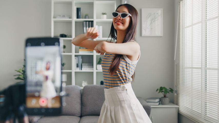 A woman filming a dance for TikTok.