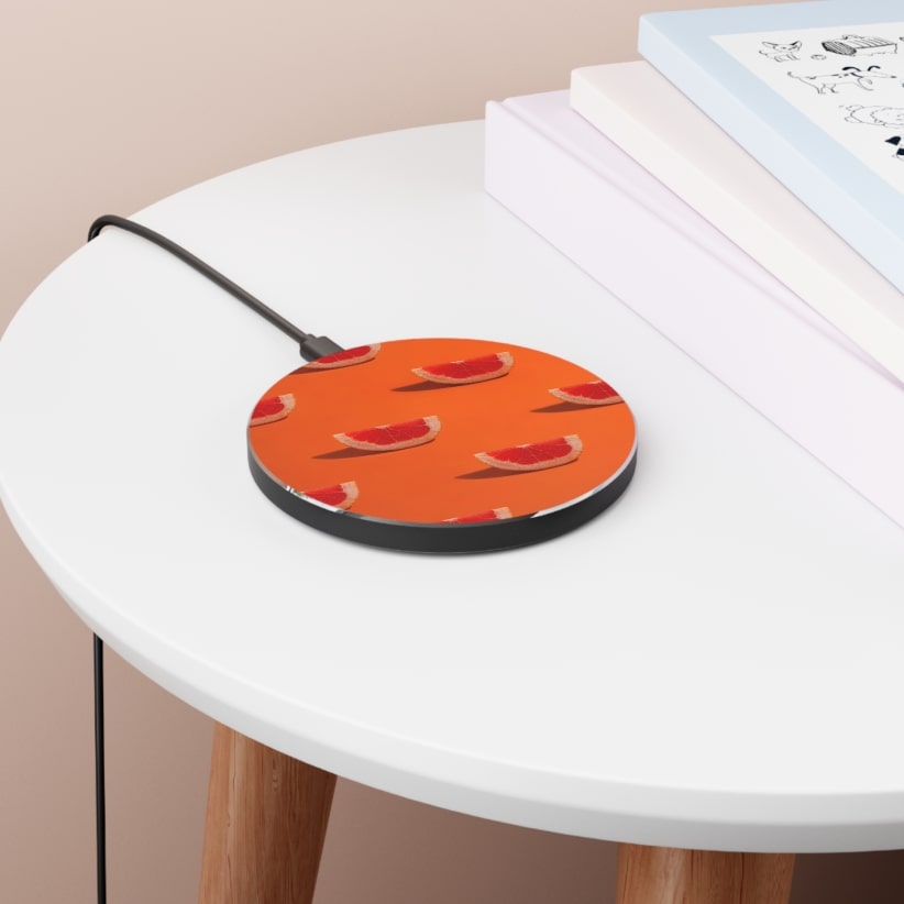 A round wireless charger with a bright orange grapefruit print.