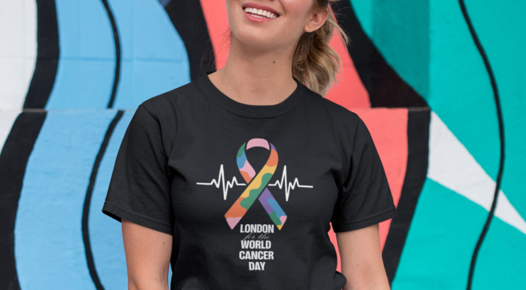 A woman in a rainbow t-shirt that reads “world cancer day”
