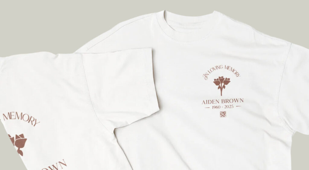 White t-shirts with a tribute design featuring roses, text "In Loving Memory," and the name "Aiden Brown, 1960-2025," conveying a commemorative tone.