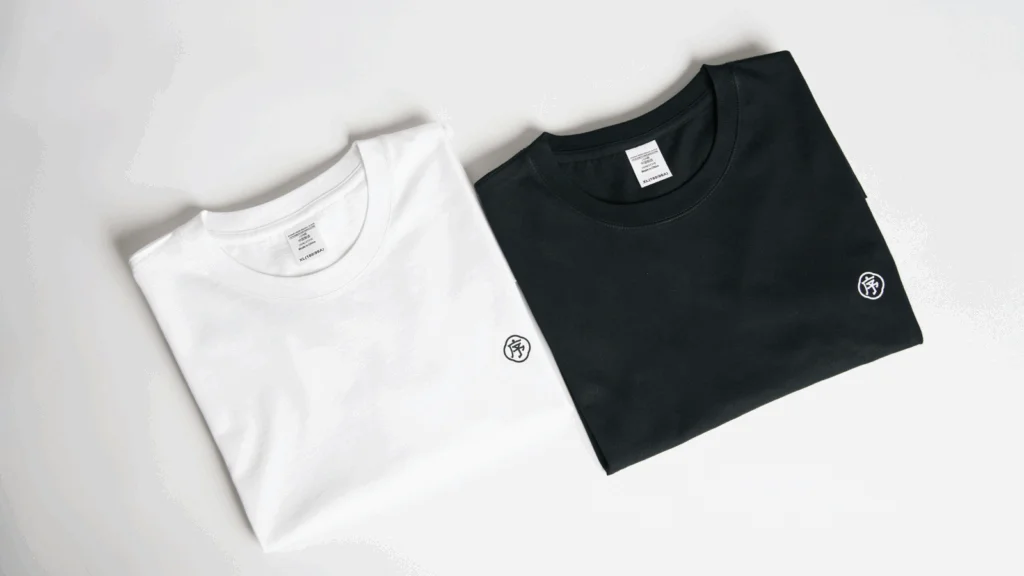 Two black and white t-shirts displayed, each featuring a logo prominently on the front.