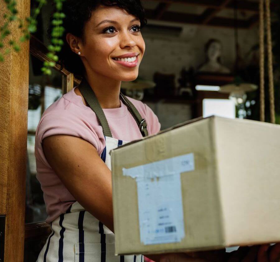 A working woman in an apron accepting a delivery package