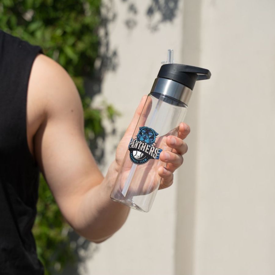 A man holding a clear personalised water bottle with a straw and a “Panthers” sports team logo printed on it.