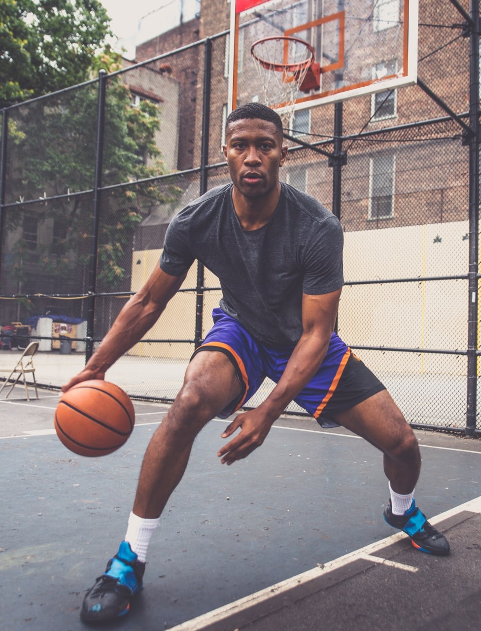 An image of a man playing basketball, while wearing custom basketball shorts.