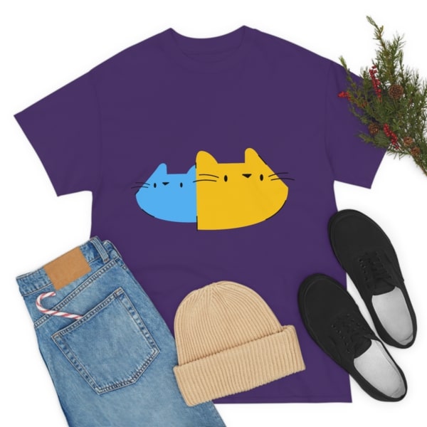A purple t-shirt with a design of yellow and blue cartoon cat faces.