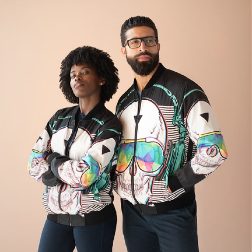 A man and a woman wearing bomber jackets with a custom design.