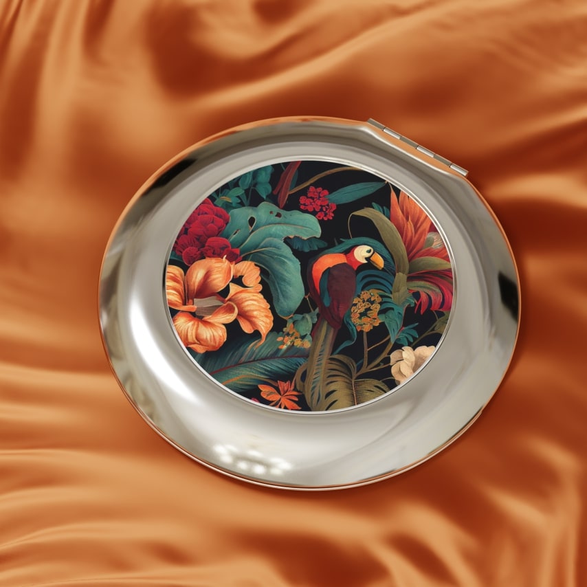 A travel mirror with a tropical flower pattern and a bird.