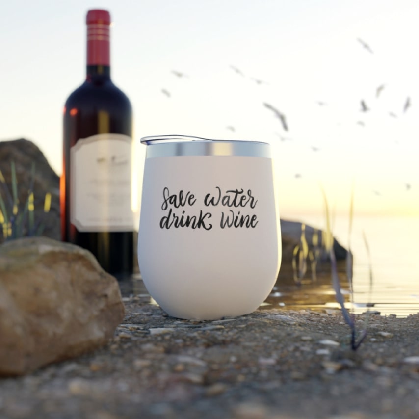 A beautiful sunset view with a custom-printed wine tumbler that says "Save Water Drink Wine".