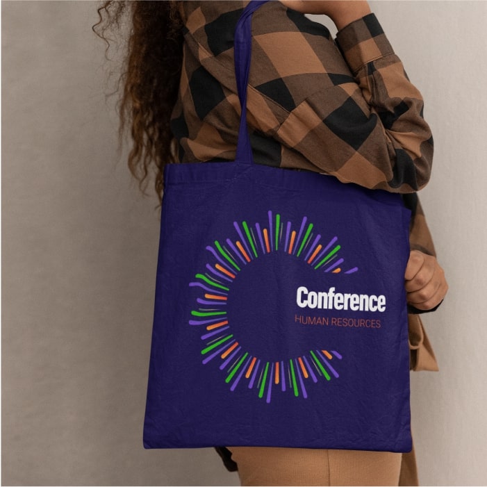 A picture of a woman holding a personalized tote bag with a logo and company branding.