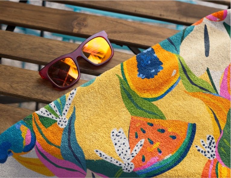A colorful towel with a pattern of fruits and flowers.