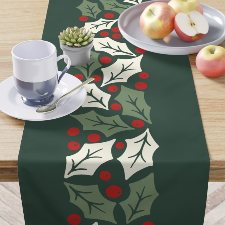 Green table runner with mistletoe design.