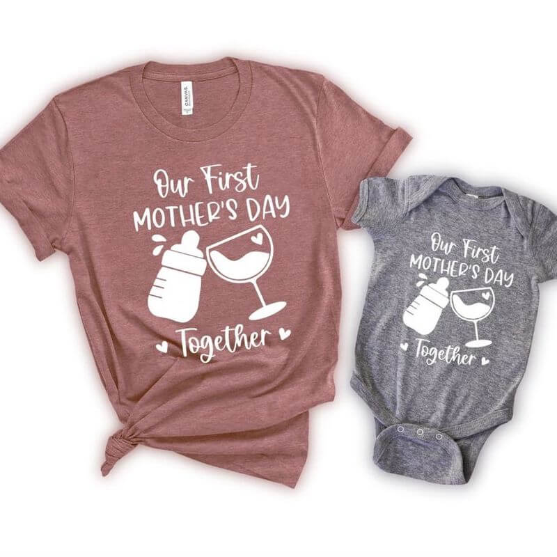 A matching t-shirt and baby bodysuit that says "Our first Mother's Day together"
