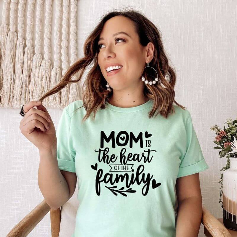 Woman posing in a t-shirt that says "Mom is the heart of the family"