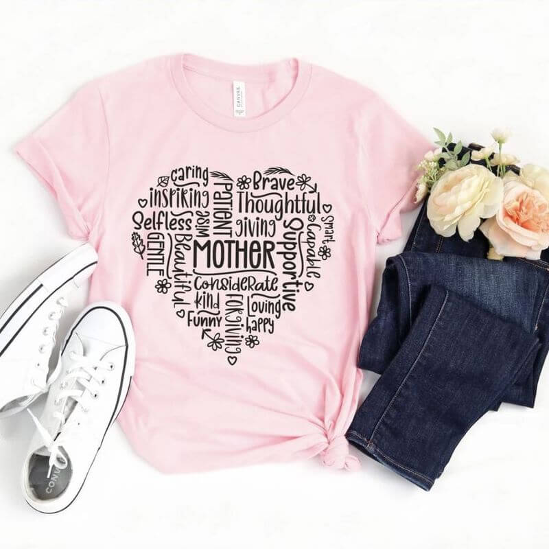 Displayed outfit with a pink t-shirt that has a heart shaped from nice adjectives with the word Mother in the middle