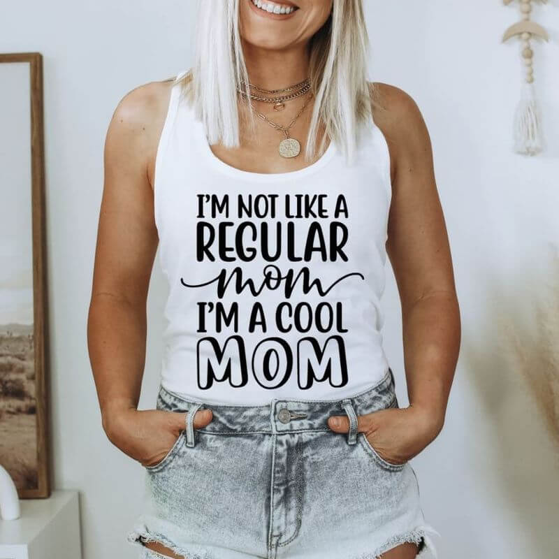 Woman posing in a tank top that says "I'm not like a regular mom, I'm a cool mom"