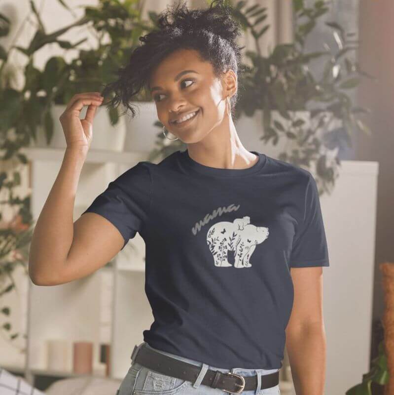 Woman posing in a shirt that says "mama" and has an image of a bear