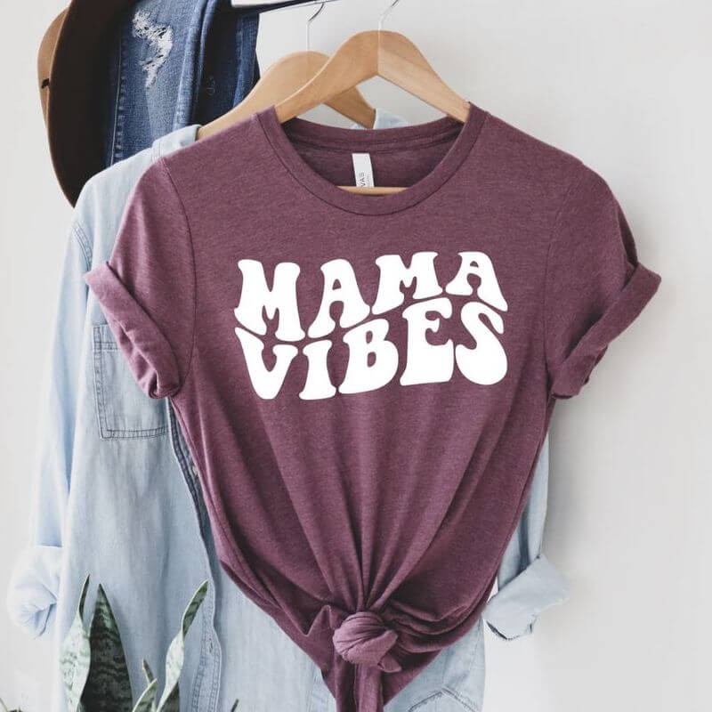 Hanging clothes with a red t-shirt on front that says "Mama Vibes"