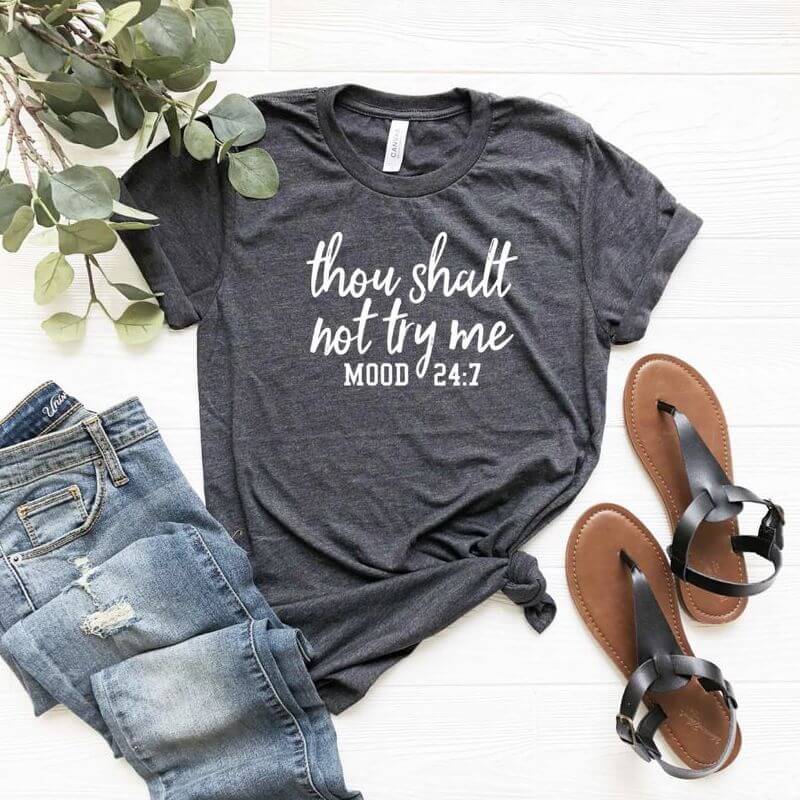 A display of an outfit and sandals. The gray t-shirt says "Thou shalt not try me. Mood 24:7"