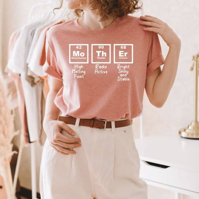 Woman posing in a creative t-shirt that spells the word Mother in chemistry elements