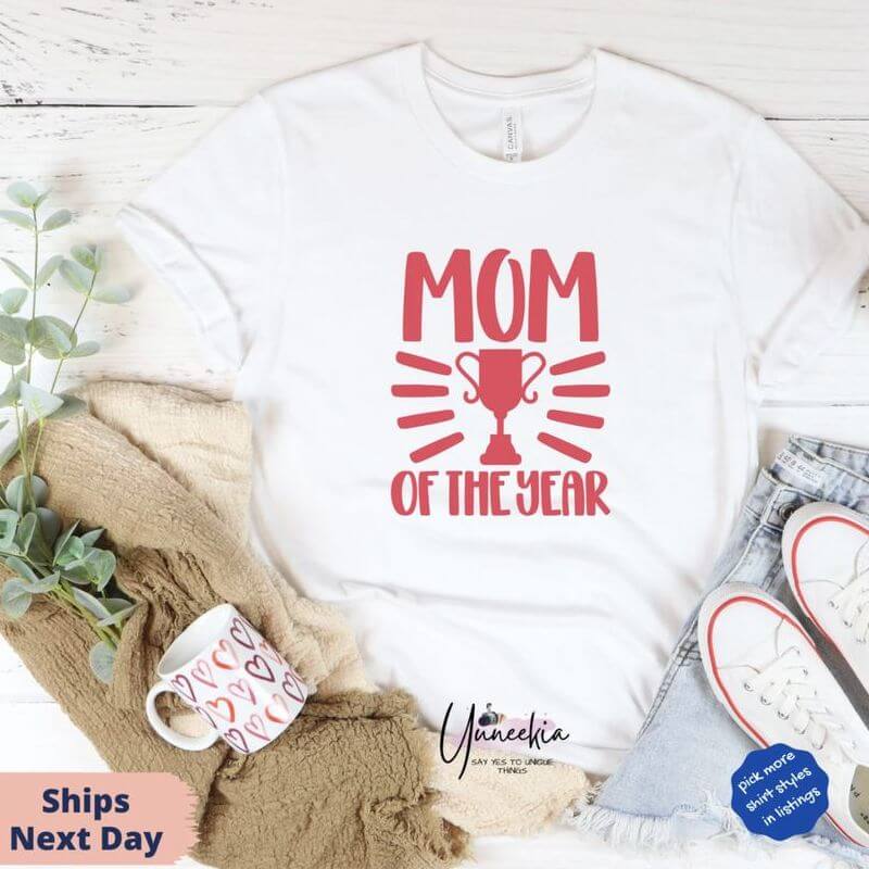 Display of an outfit with a white t-shirt that has "Mom of the year" cup design