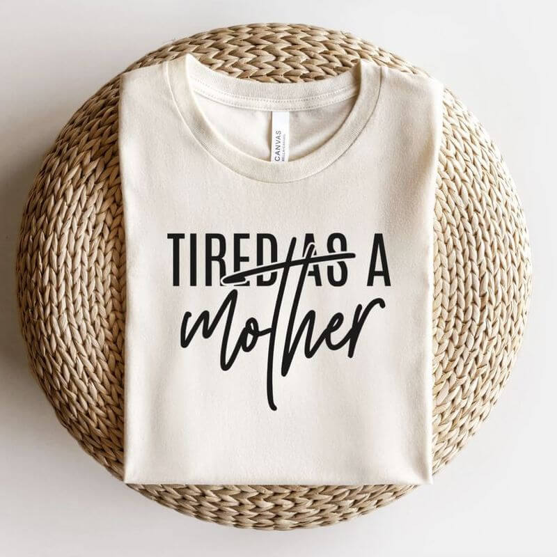 A neatly folded t-shirt that says "Tired as a mother"