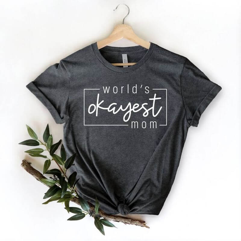 A hanging grey shirt that says "World's okayest mom"