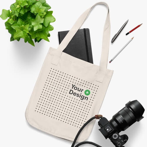 A mockup of an organic canvas tote bag lying on a white surface.