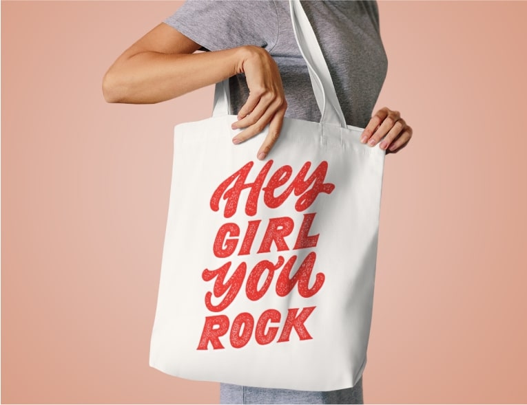 An image of a woman holding a custom tote bag with text.