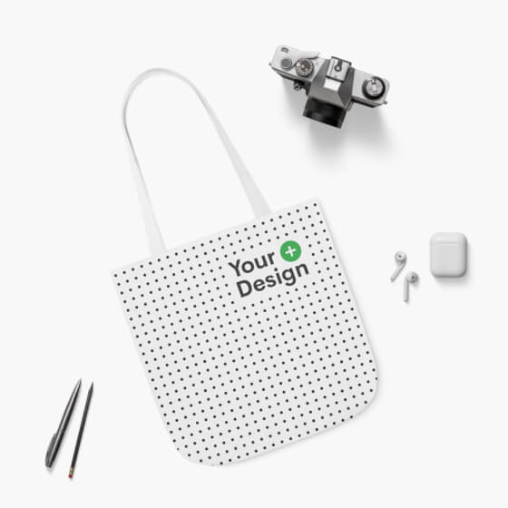 A mockup of a polyester canvas tote bag lying on a white surface.
