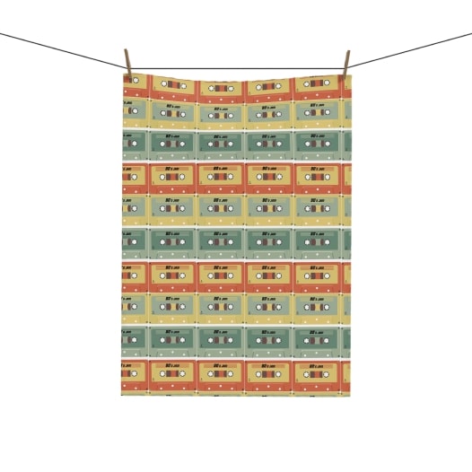 Tea towel with an all-over-print of cassette tape pattern in green, blue and orange tones.