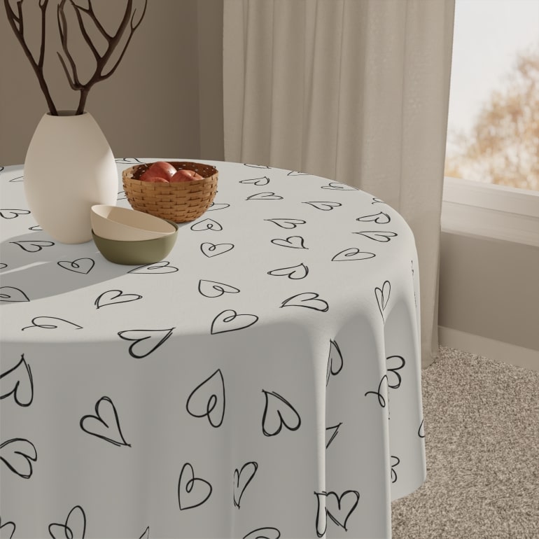White table cloth with minimalistic heart pattern on a round table.