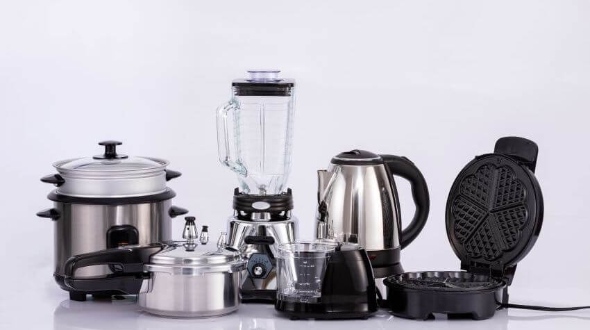 A set of kitchen electronics – electric kettle, waffle pan, blender, and multi-cooker.