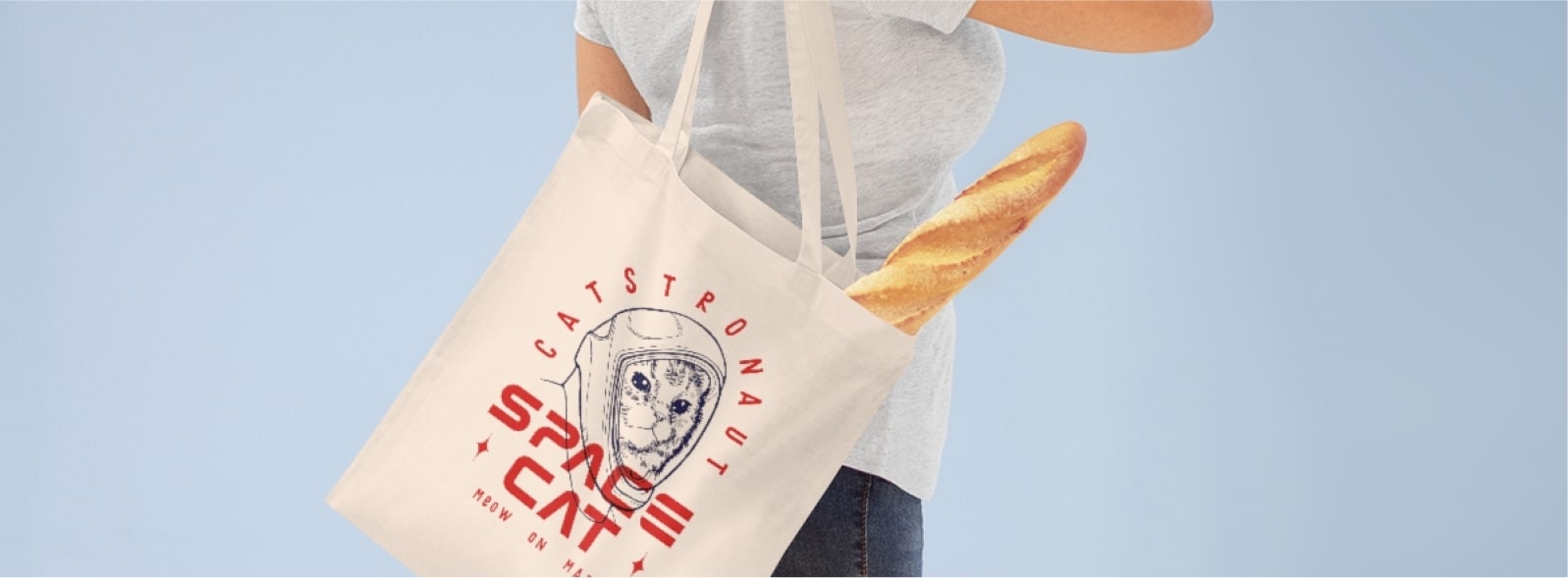 An image of a woman holding a customized tote bag on her shoulder with a baguette inside.
