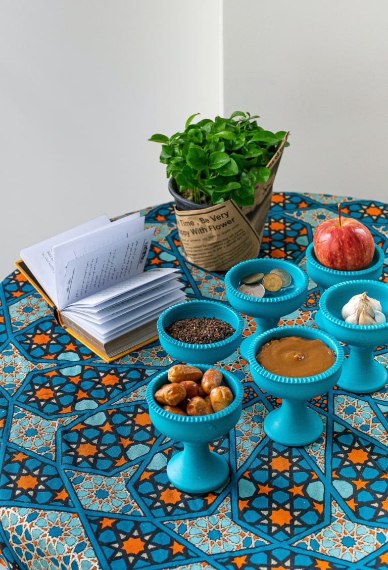 Table cover with an elaborate blue and orange arabesque design.