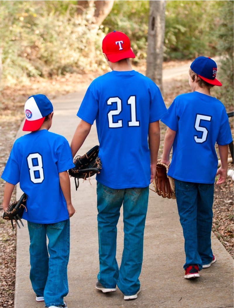 An image with three kids wearing custom baseball jerseys.