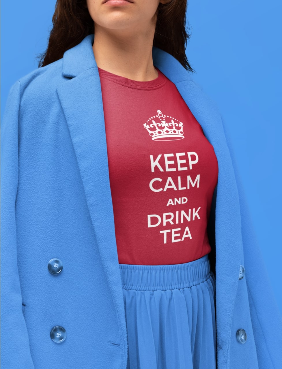A woman wearing blue skirt, blue blazer, and a red t-shirt that says "Keep calm and drink tea"