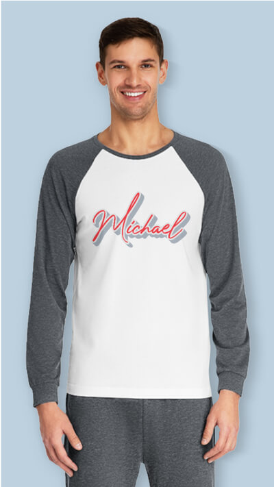 Man in a gray and white pajama set with the name “Michael” printed on the front of the long sleeve tee.
