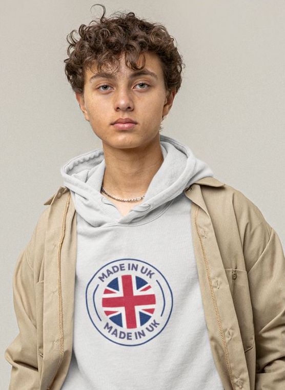 Teenager wearing a white hoodie with a round UK flag design in the middle, with the text “Made in the UK” wrapped around it.