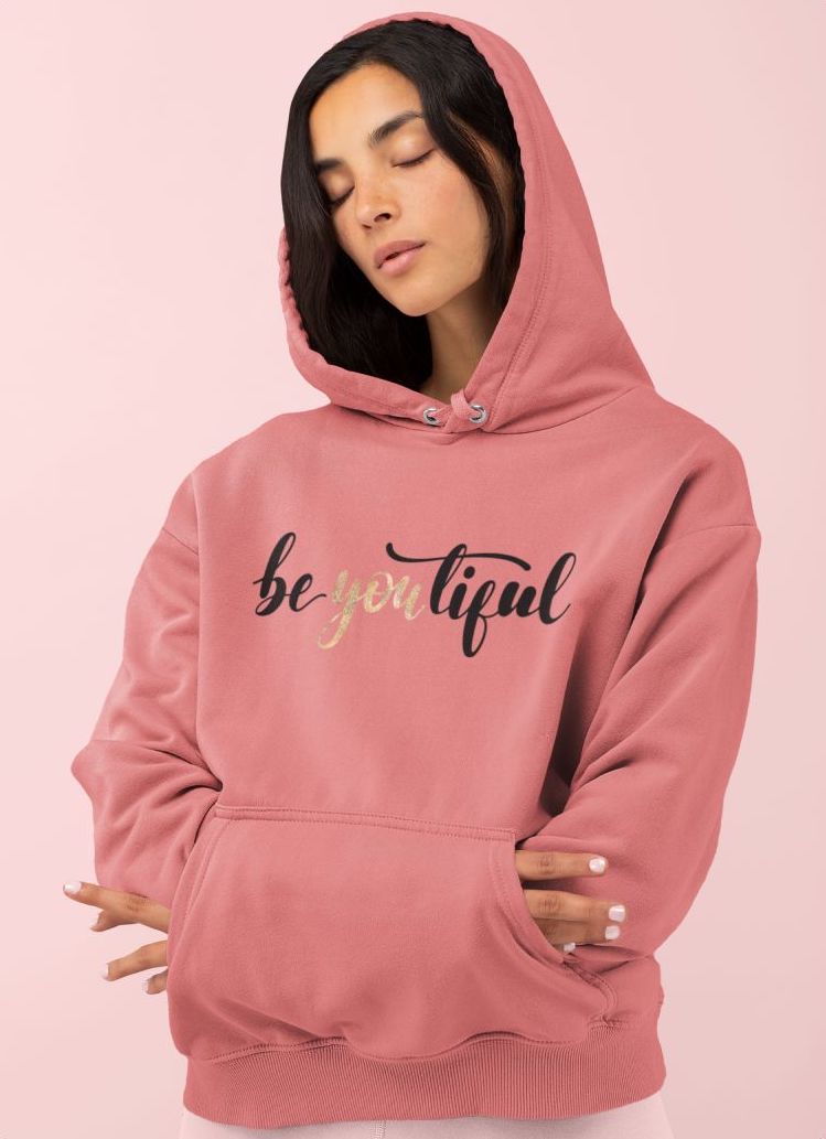 Woman in a pink custom hoodie with the text “Be You Tiful” printed on.