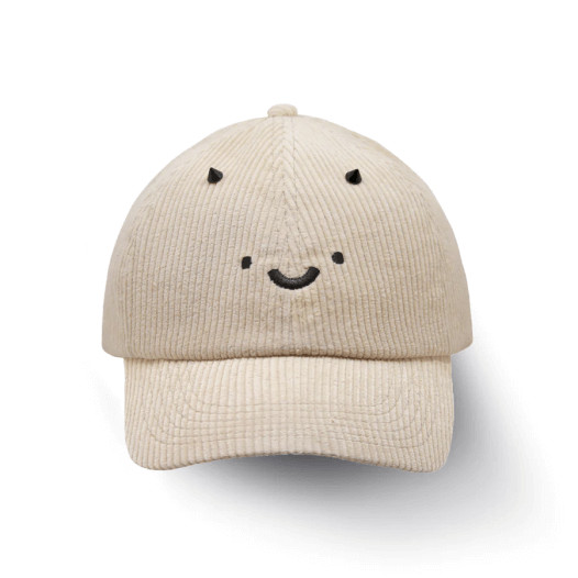 A beige cap with tiny horns and a smiley face design.