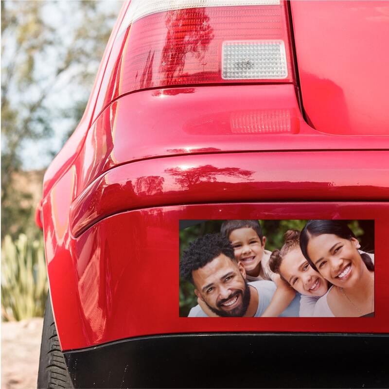 Car with a rear bumper sticker showing a photo of a happy family of four.