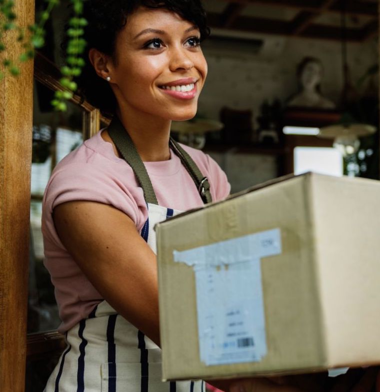 A hardworking woman in an apron happily accepting her package