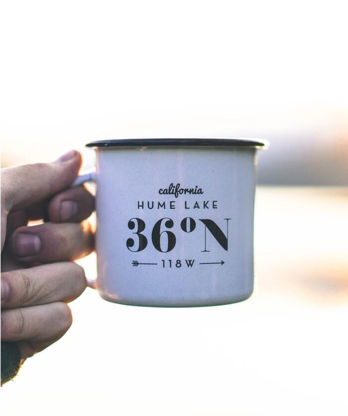 White enamel mug with the text “California Hume Lake 36°N 118 W.”