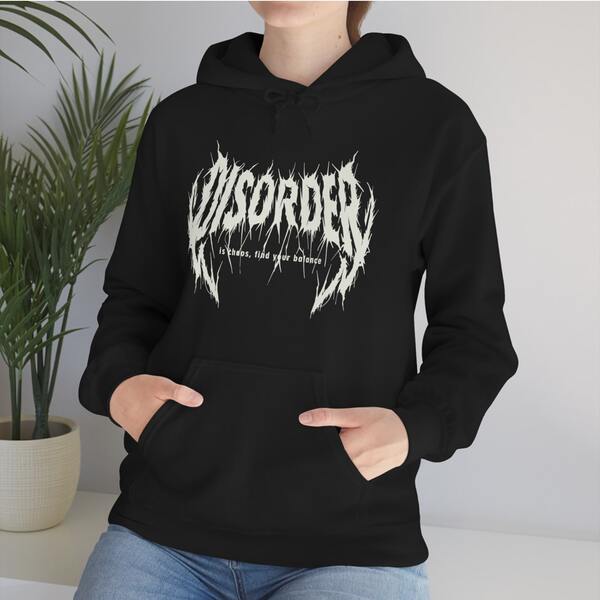 An image of a woman wearing a black custom hoodie with a band logo.