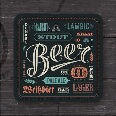 Coaster with the word “Beer” in the center surrounded by names of beer types in varying fonts, such as “Stout,” “Pale ale,” “Lager,” and more.
