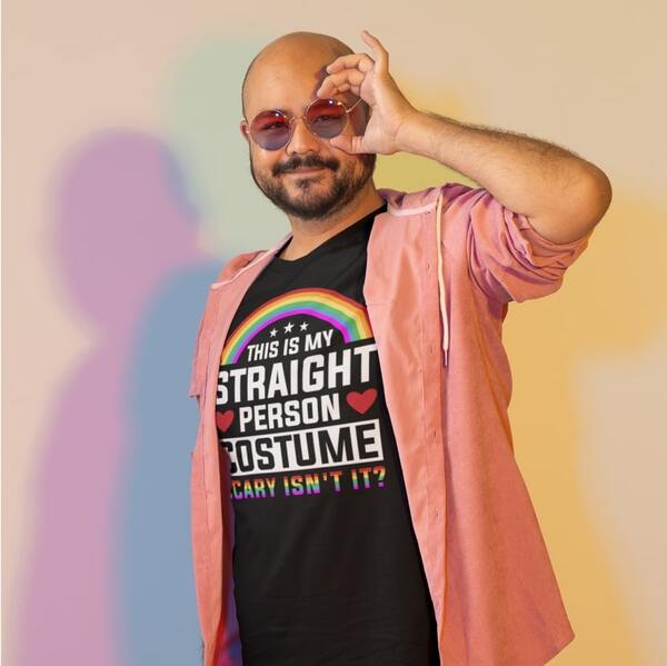Model poses with tinted sunglasses while wearing a custom t-shirt with a text graphic “This is my straight person costume. Scary, isn’t it?” printed on the front.